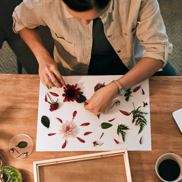 Hands creating a pressed flower mandala as part of a sustainable DIY art practice