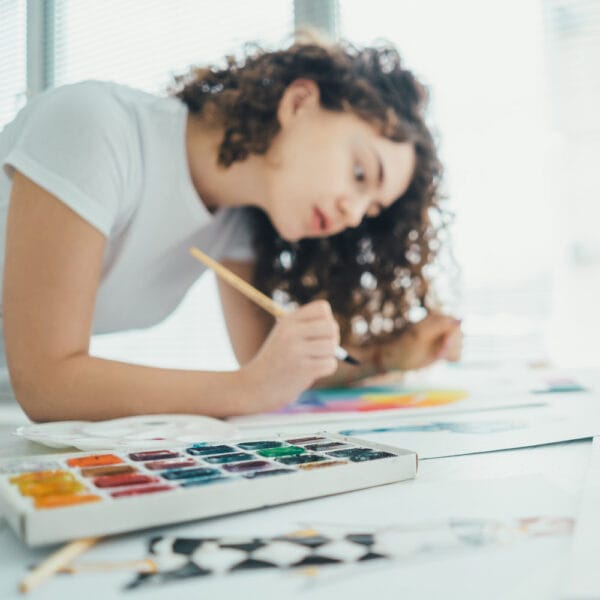woman painting mindfully with watercolors, embodying the spirit of pressed flower art ideas and calm creativity