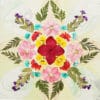 Colorful circular mandala using a pressed flower kit, with pink, red and turquoise flowers on soft pastel background