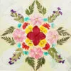 Colorful circular mandala using a pressed flower kit, with pink, red and turquoise flowers on soft pastel background