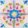 Star-shaped floral mandala made with pressed flower kit, featuring layered petals and fern details