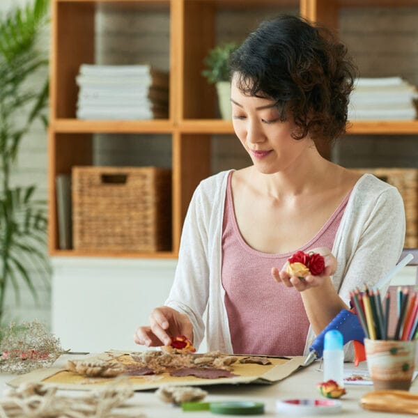 Woman gently arranging natural materials for a sustainable DIY art project