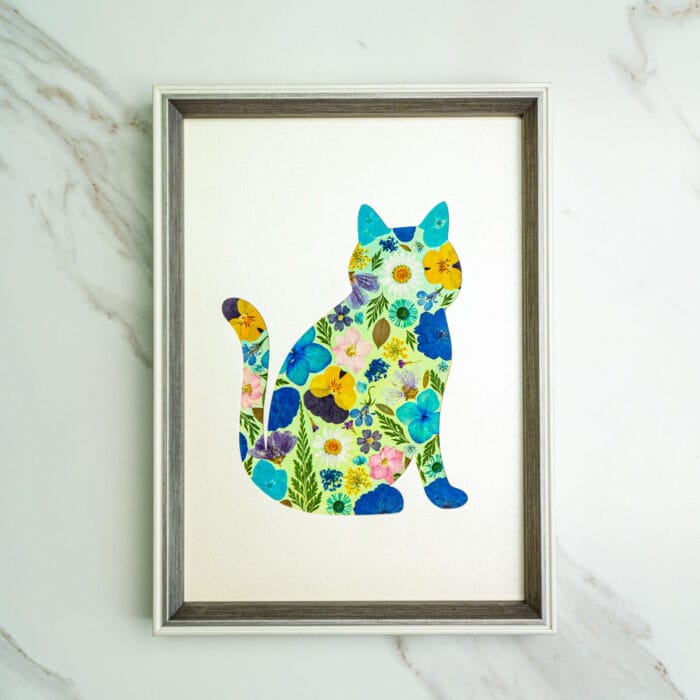 Pressed flower kit cat silhouette with mixed blue, yellow, and pink pressed flowers