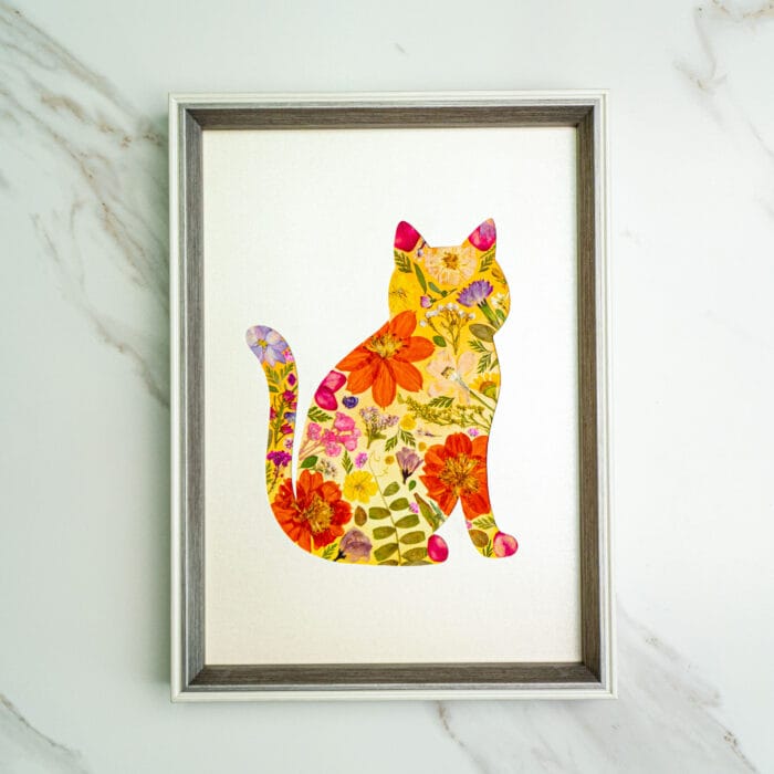 Pressed flower kit cat silhouette with warm orange, red, and pink pressed flowers