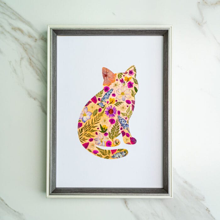 Pressed flower kit cat silhouette with pink and yellow warm-tone flowers