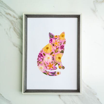 Pressed flower kit cat silhouette with soft pink background and yellow flowers