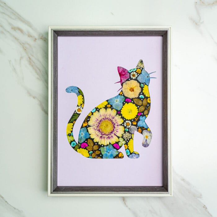 Pressed flower kit cat silhouette with sunflower, blue and pink flowers on lavender background