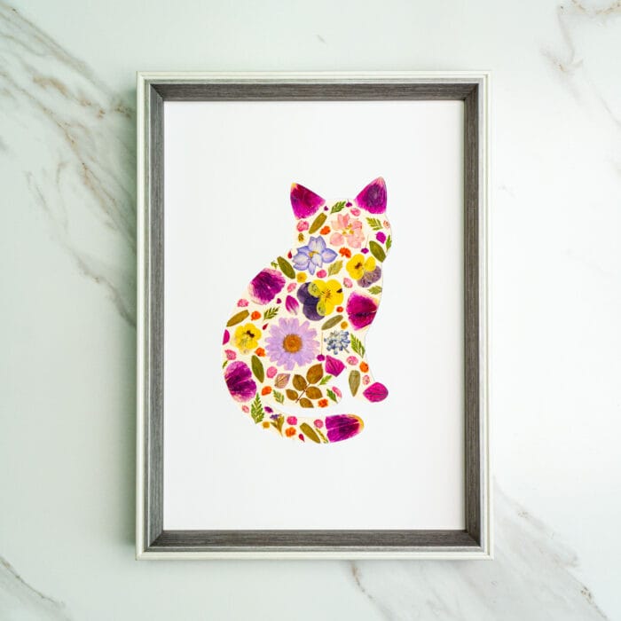 Pressed flower kit cat silhouette with vivid pink, purple, and yellow flowers