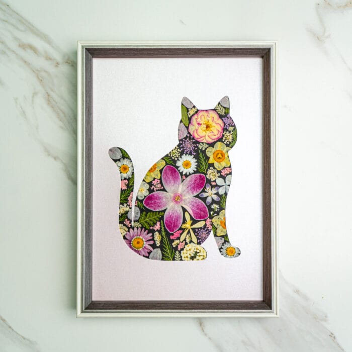 Pressed flower kit cat silhouette with pink and mixed floral pattern on soft pink background