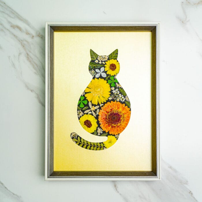 Pressed flower kit cat silhouette with yellow and orange dried flowers on gold background