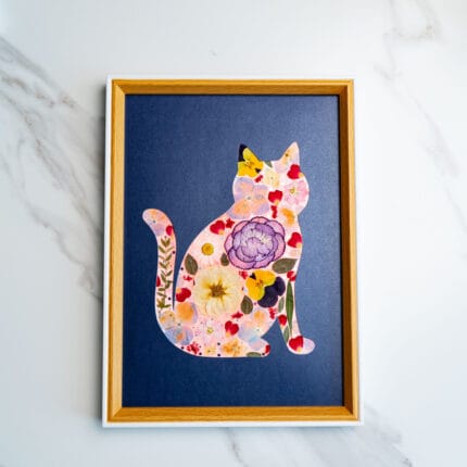 Pressed flower cat with red, yellow, and peach florals on a deep navy background.