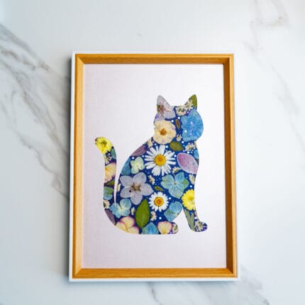 Pressed flower cat with daisy and hydrangea details in blue and yellow tones, on a soft lavender backdrop.