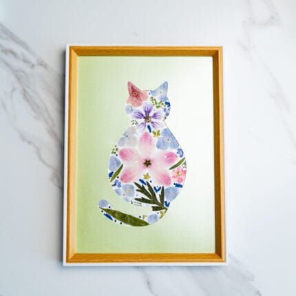 Gentle pressed flower cat featuring soft pink and blue tones on a light green background.