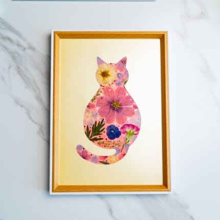 Warm-toned pressed flower cat with coral and peach florals on a golden beige background.