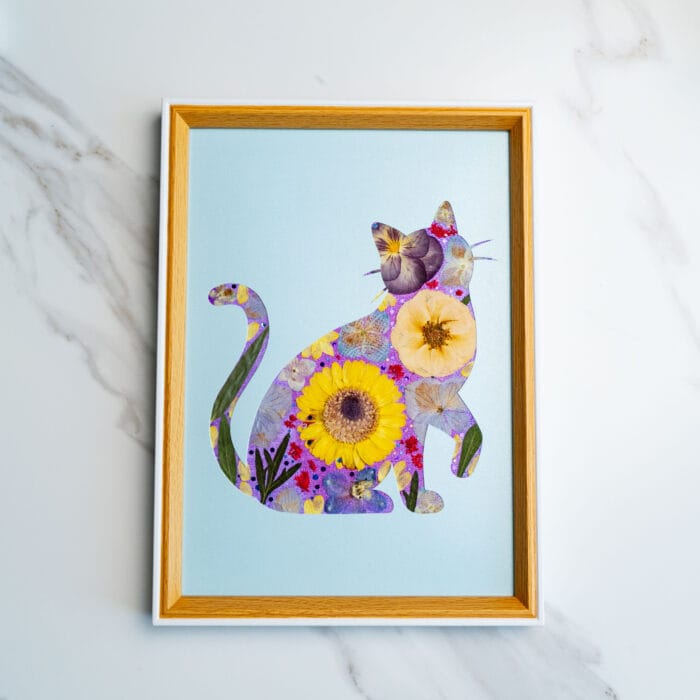 Bright and cheerful cat silhouette with sunflowers and poppies on a sky blue background.