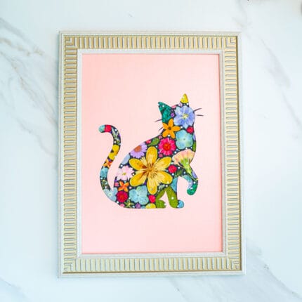 Pressed flower cat artwork of a graceful sitting cat, delicate floral collage on pastel pink background