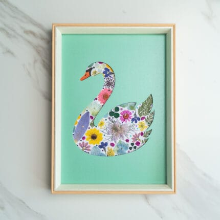 Pressed flower art of a swan silhouette filled with flowers on a green background