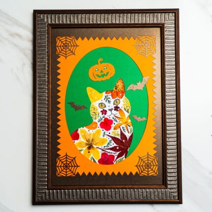 Halloween pressed flower cat with pumpkins, bats, and spider web accents, framed in bronze.