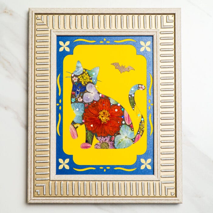 Pressed flower cat artwork with a bright yellow background, red central bloom, and a small bat accent.