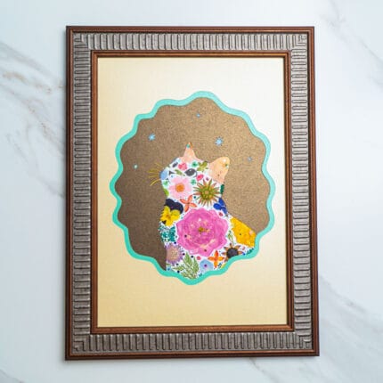 Pressed flower cat artwork with colorful blooms and stars, set in a scalloped frame design against a golden background.