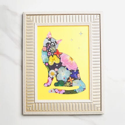 Pressed flower cat silhouette with colorful blossoms on dark base, wearing a red bow, set against a bright yellow background with stars, framed in light gold frame.
